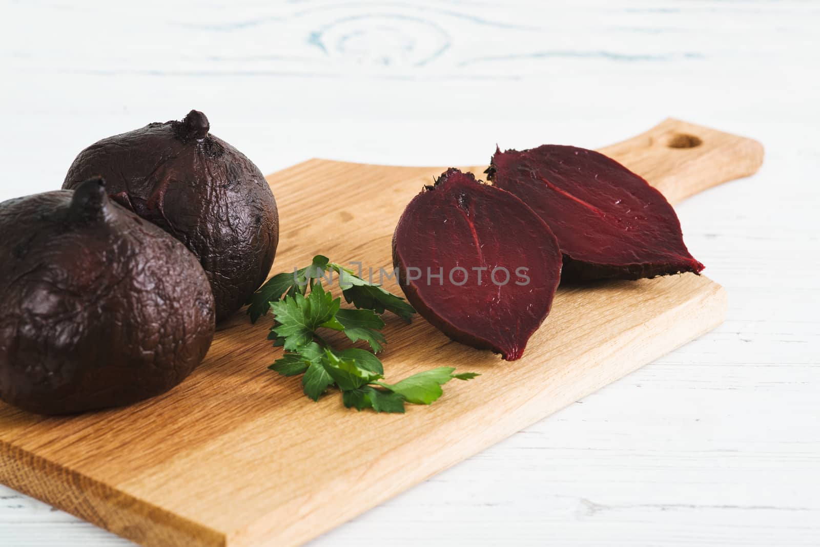Boiled beets on board, light wooden background