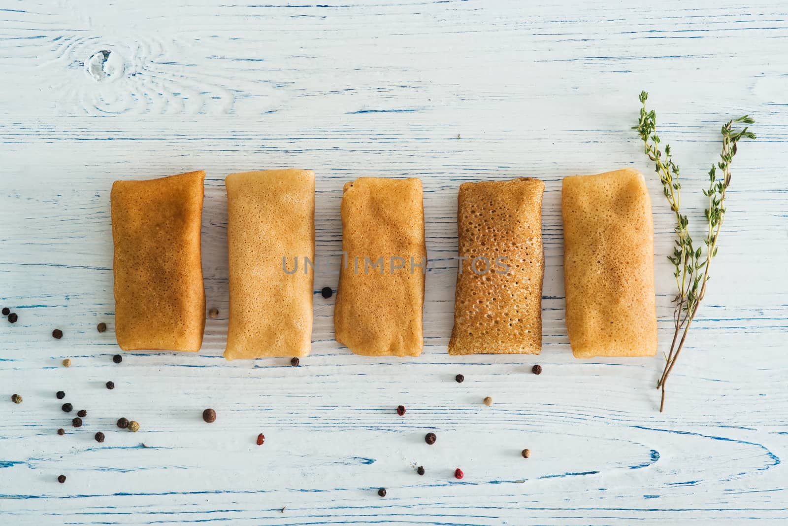 Stuffed pancakes on light wooden background