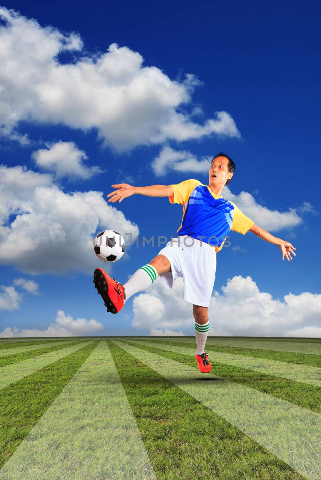 male football player and soccer ball floating on green grass of sport field use for soccer competition theme and team sport topic