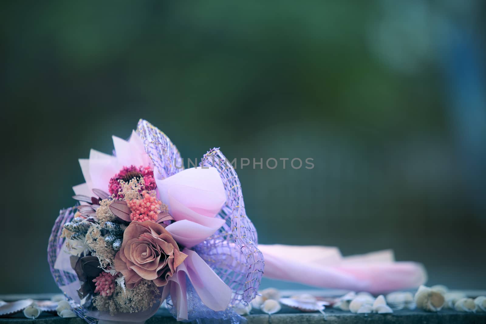 dry flowers bouquet lying on wood table with blurry background by khunaspix