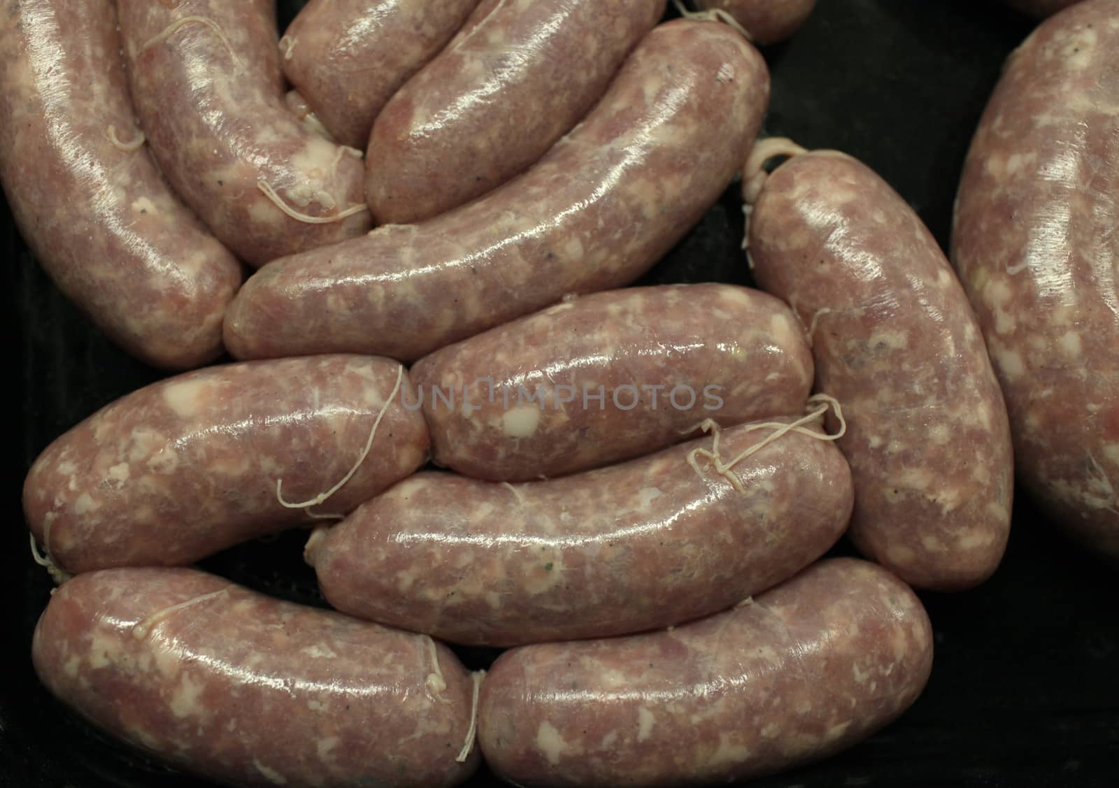 raw meat sausages on black background  above close-up