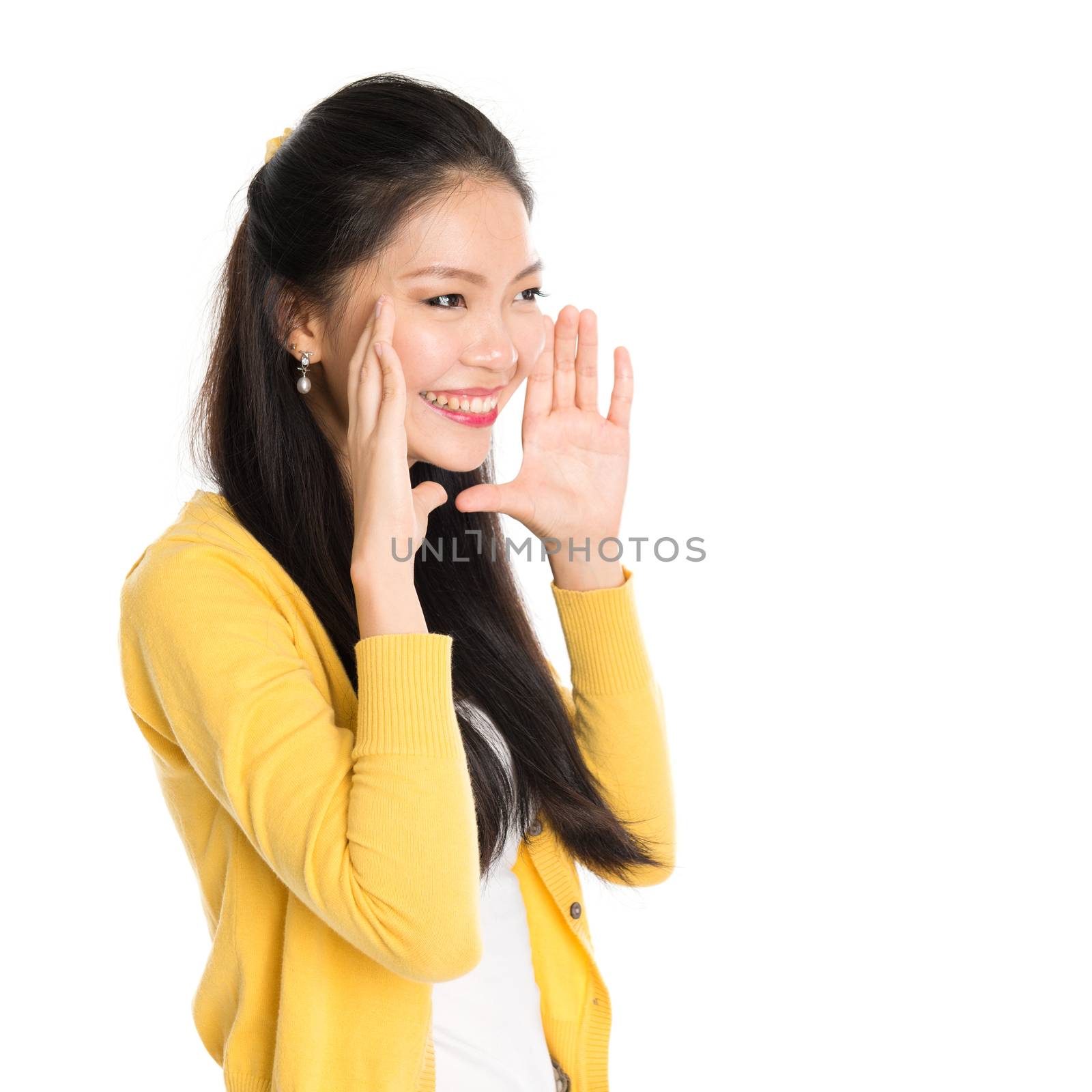 Portrait of Asian girl, shouting and looking at side, standing isolated on white background.