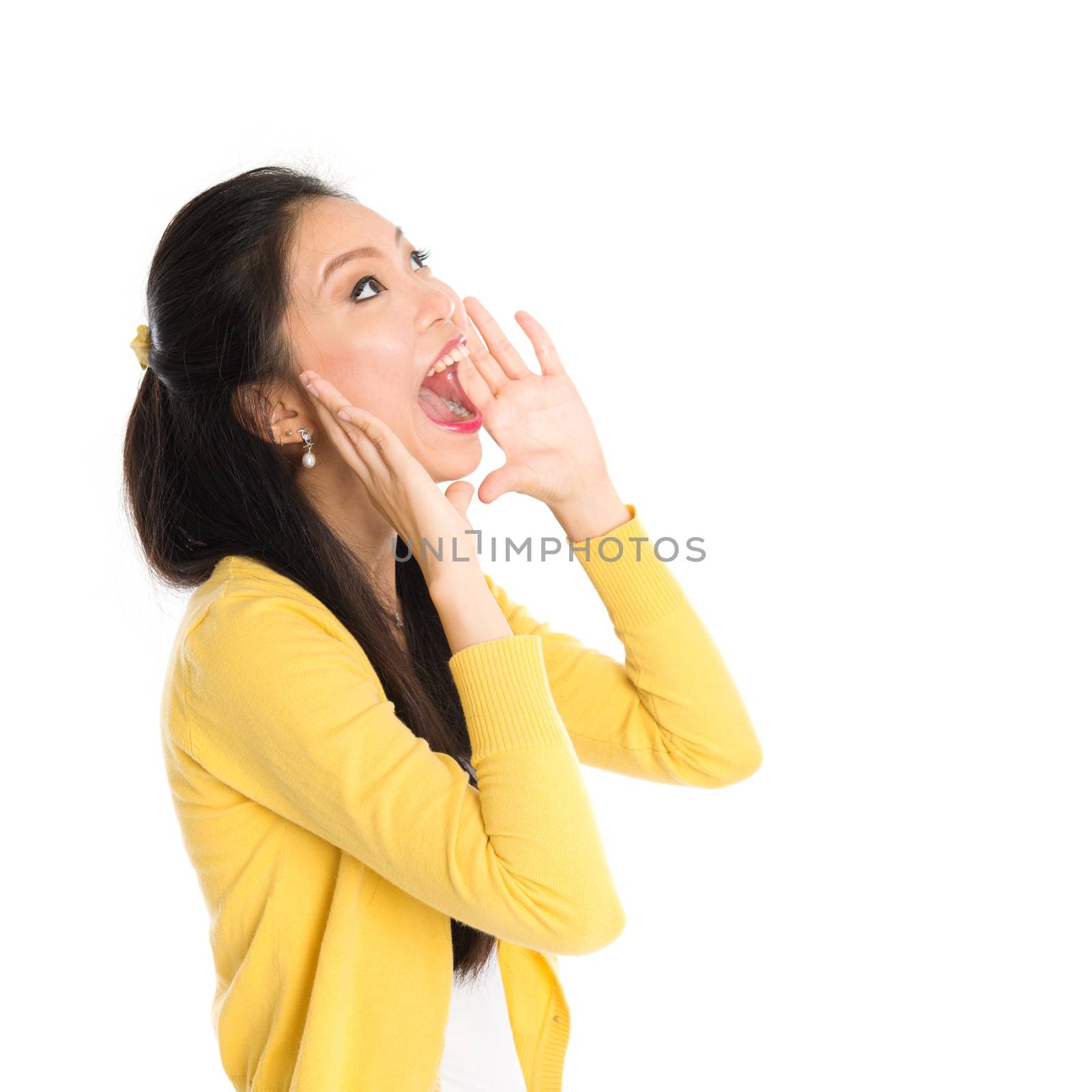 Portrait of Asian girl, shouting and looking up, standing isolated on white background.