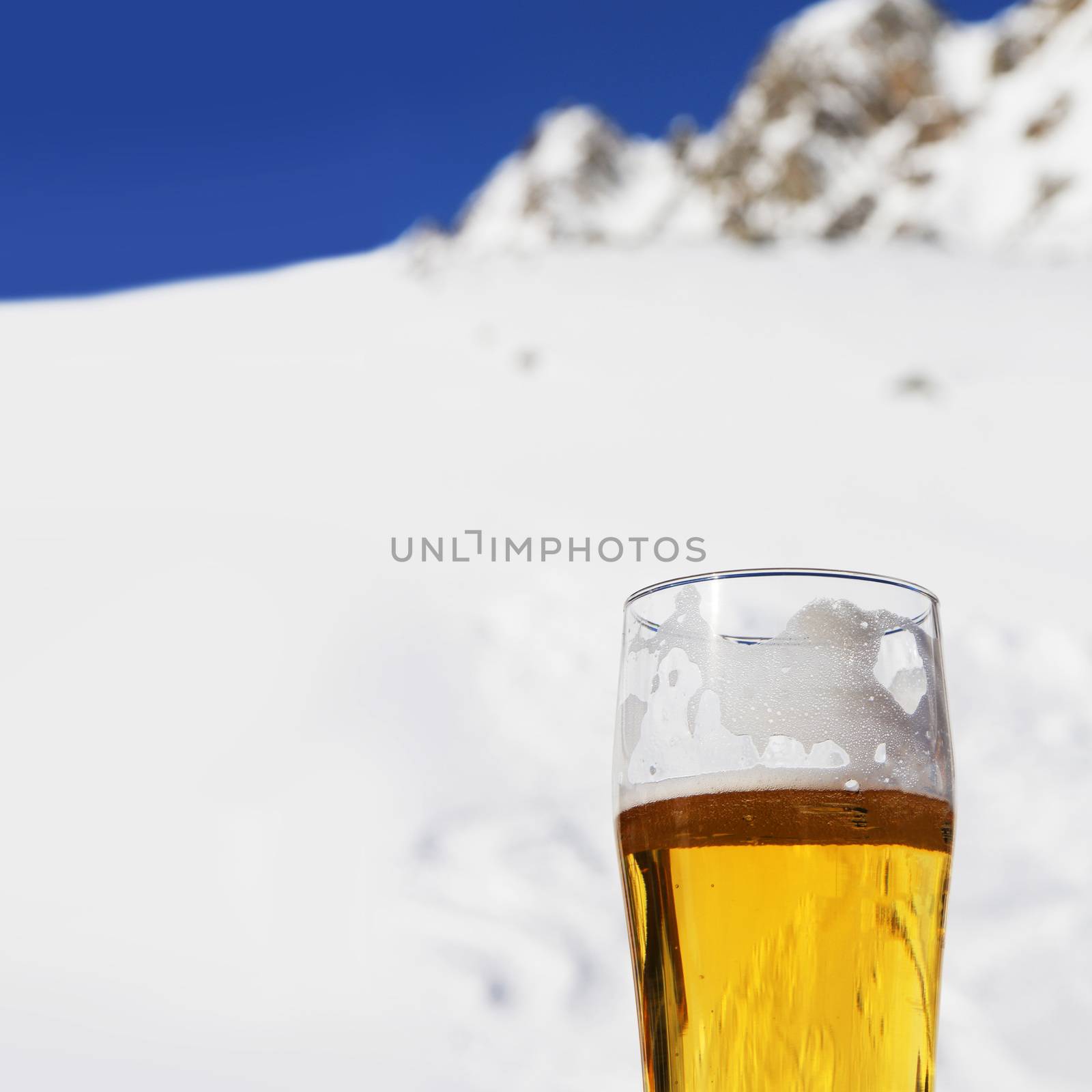 Glass of beer over winter mountain landscape