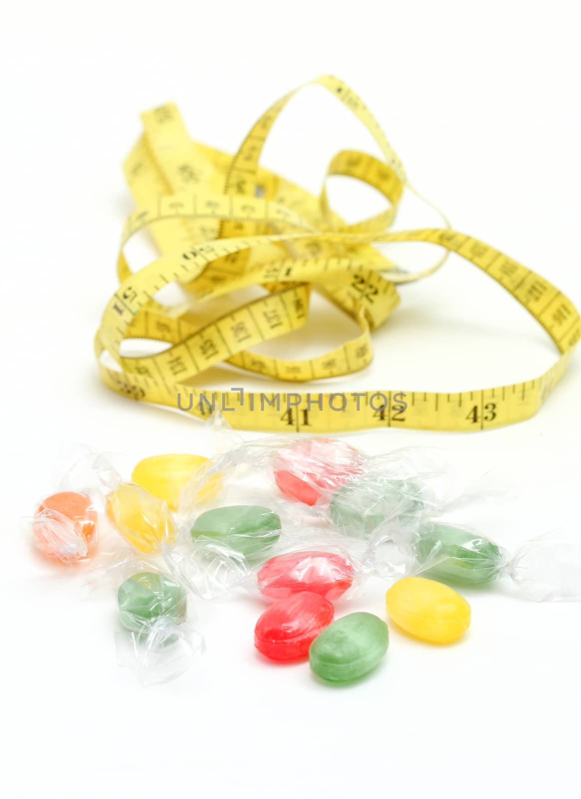 picture of a the colored fruit taste candies. and tape measure .sweet food concept