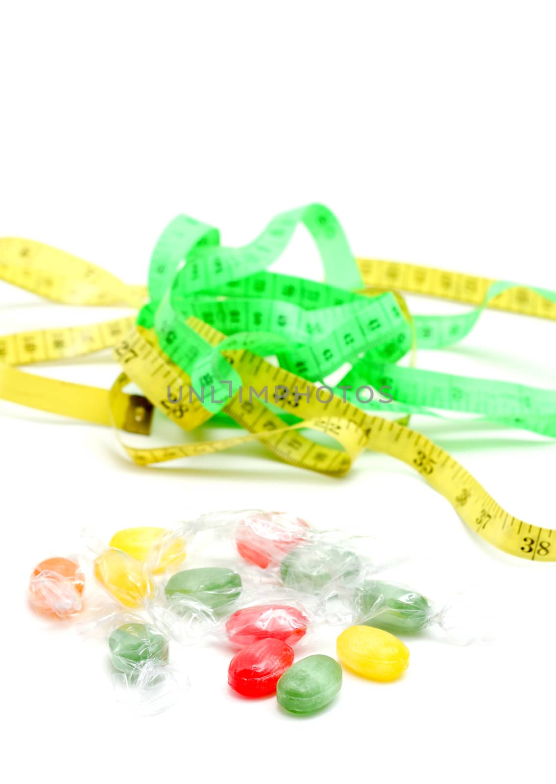 picture of a the colored fruit taste candies. and tape measure .sweet food concept