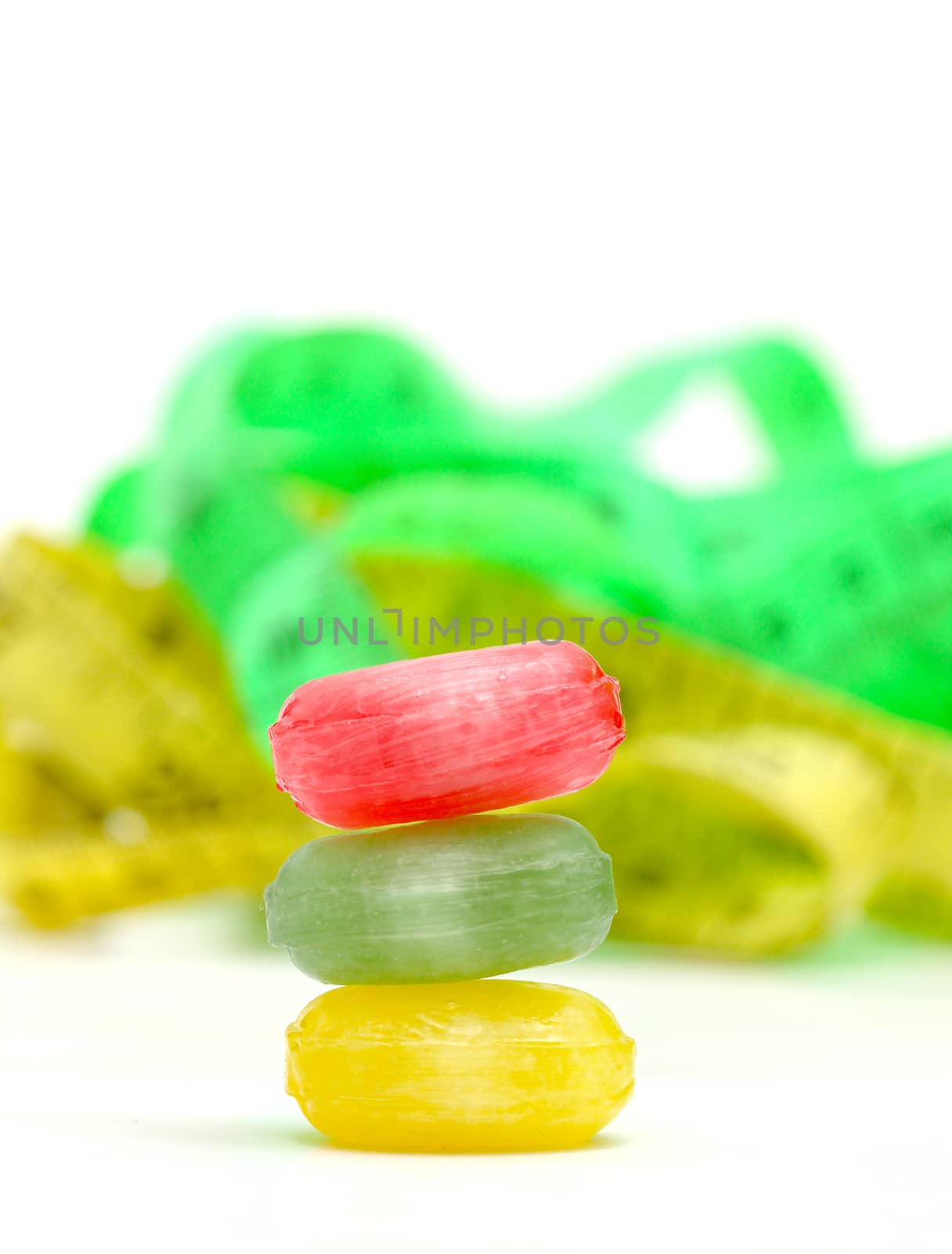 picture of a the colored fruit taste candies. and tape measure .sweet food concept