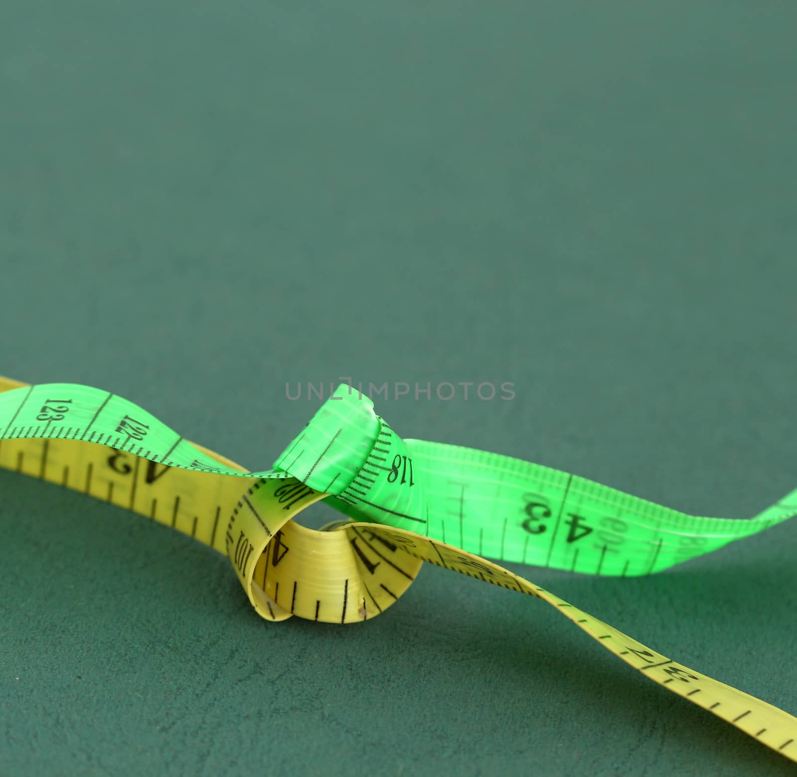 picture of a yellow and green tape measure on green background
