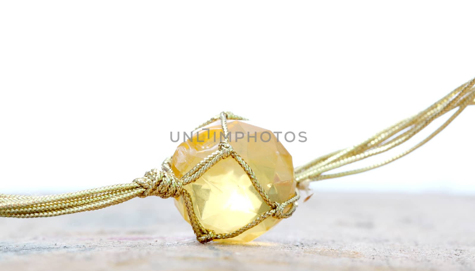 picture of a necklace with cheap plastic gems with golden colored rope