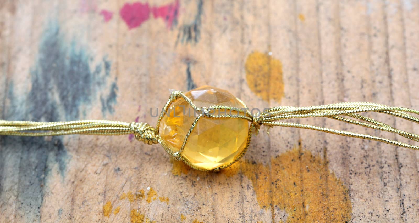 picture of a necklace with cheap plastic gems with golden colored rope