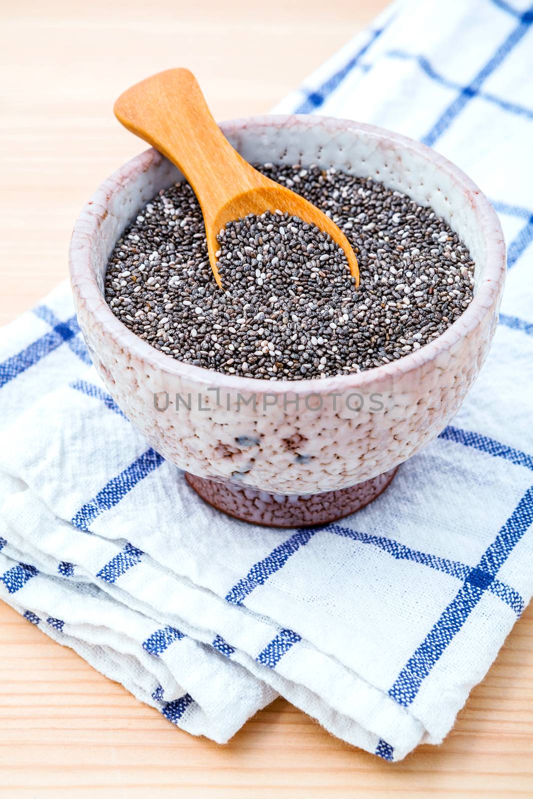 Nutritious chia seeds in ceramic bowl on wooden table for diet f by kerdkanno