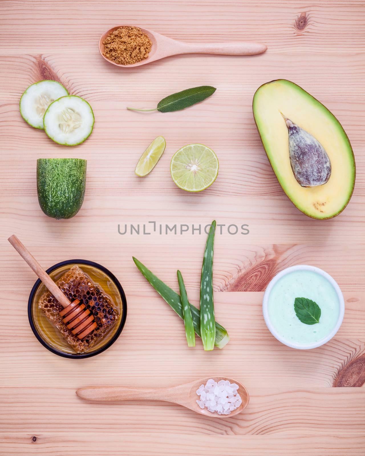 Homemade skin care and body scrub with natural ingredients avocado ,aloe vera ,lemon,cucumber and honey set up on wooden background.