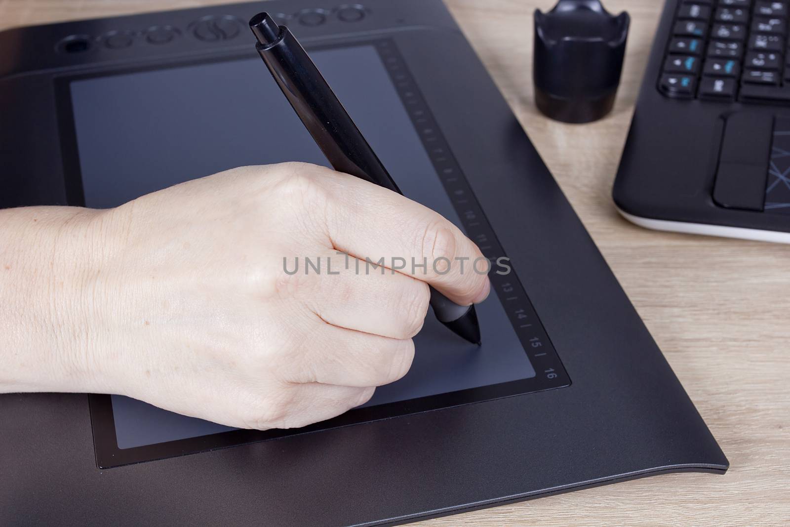 Hand graphic designer with a digital pen and tablet