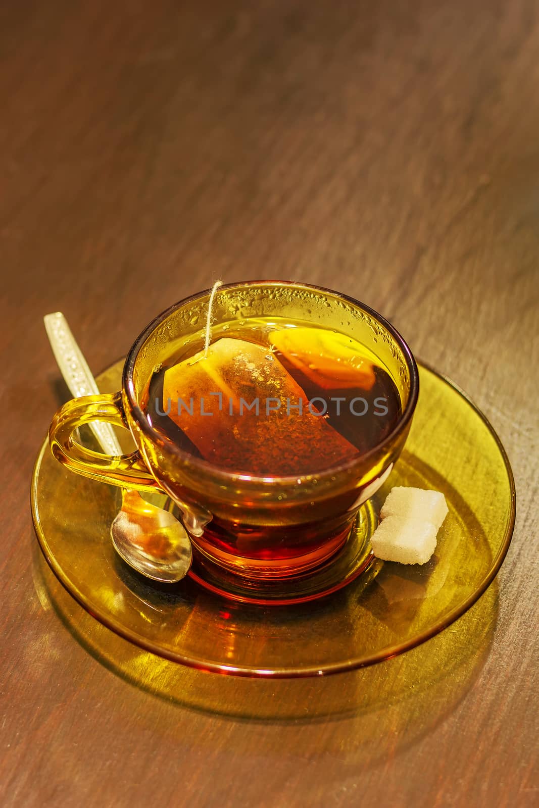 Hot tea cup with tea bag,spoon and sugar on table