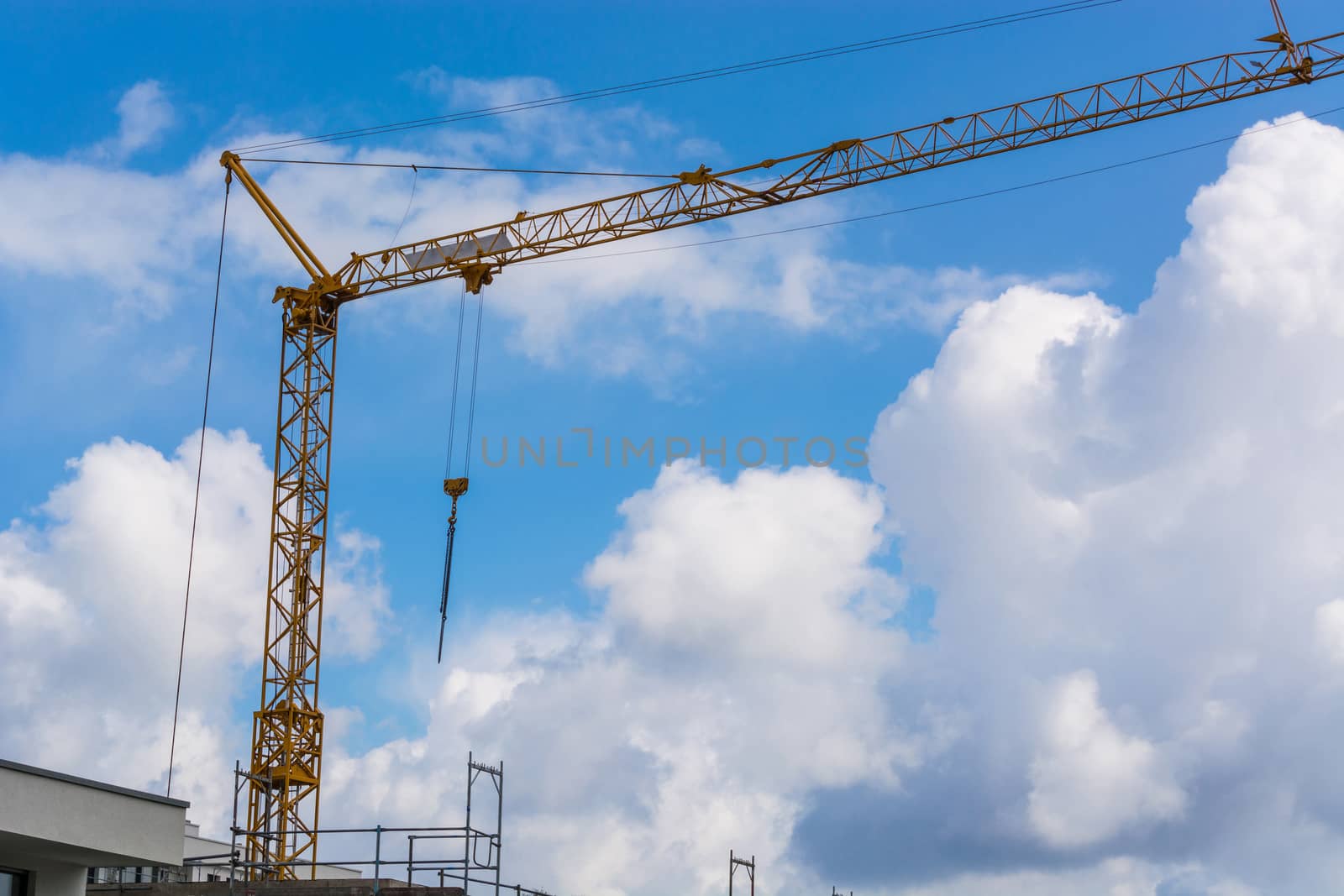 Construction crane against blue sky photographed, space for labeling.