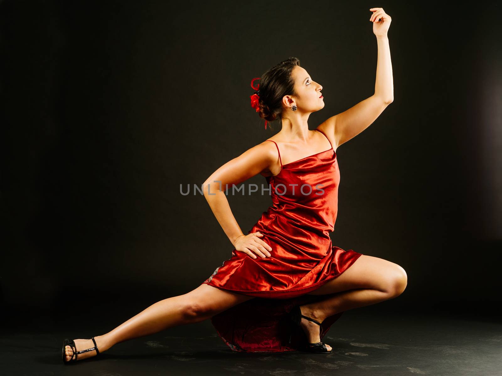 Photo of a young beautiful woman performing tango moves.