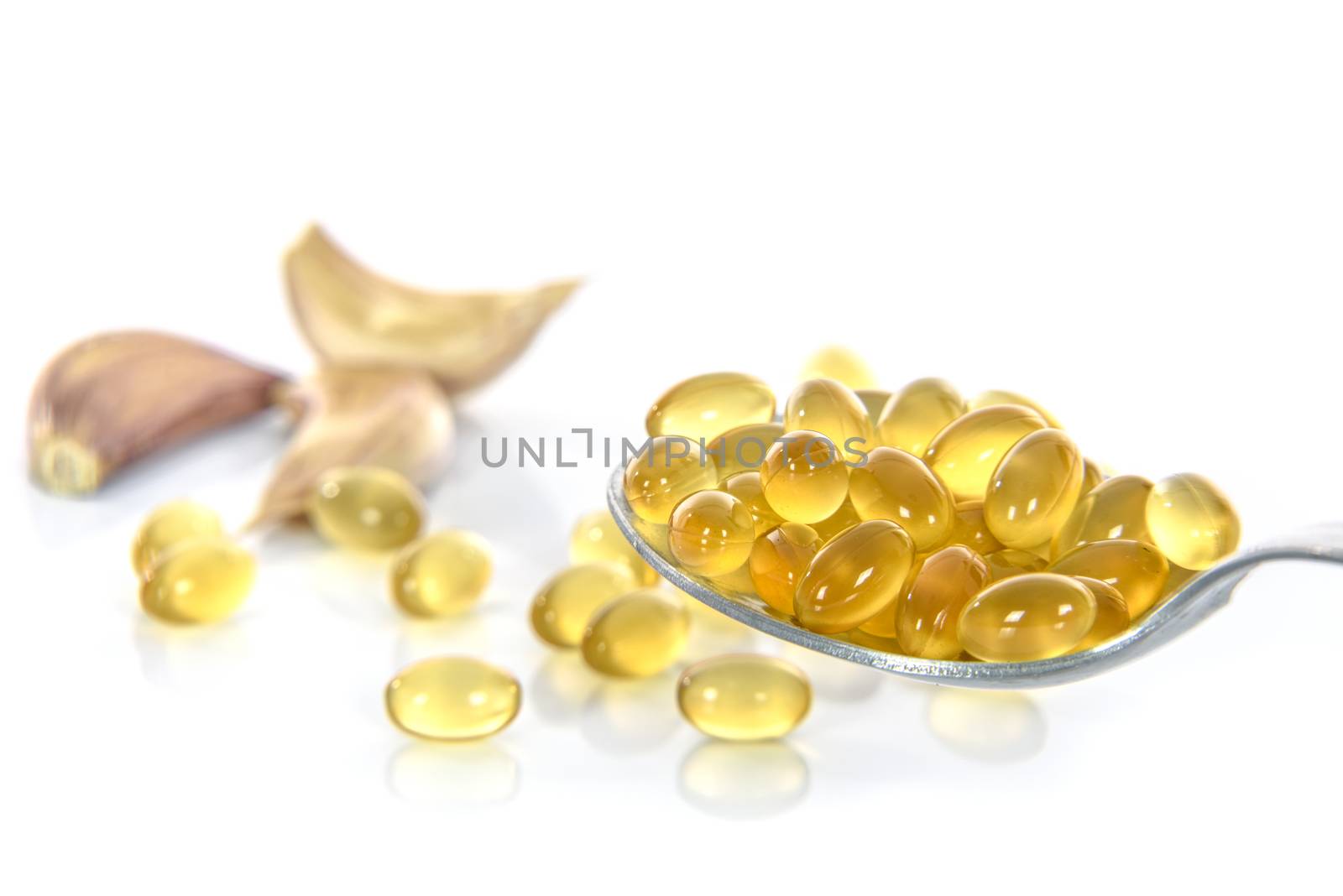 Garlic oil capsules with garlic cloves isolated on white background 