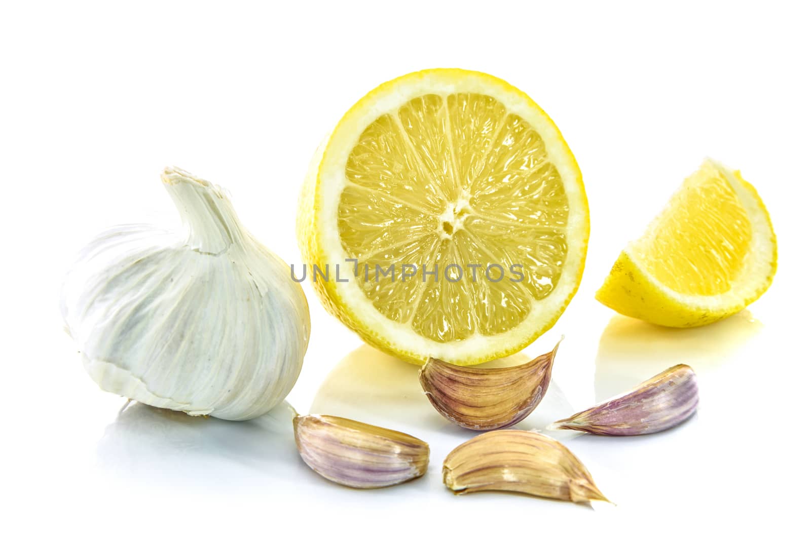 Garlic bulb and clove with sliced lemon isolated on a white background