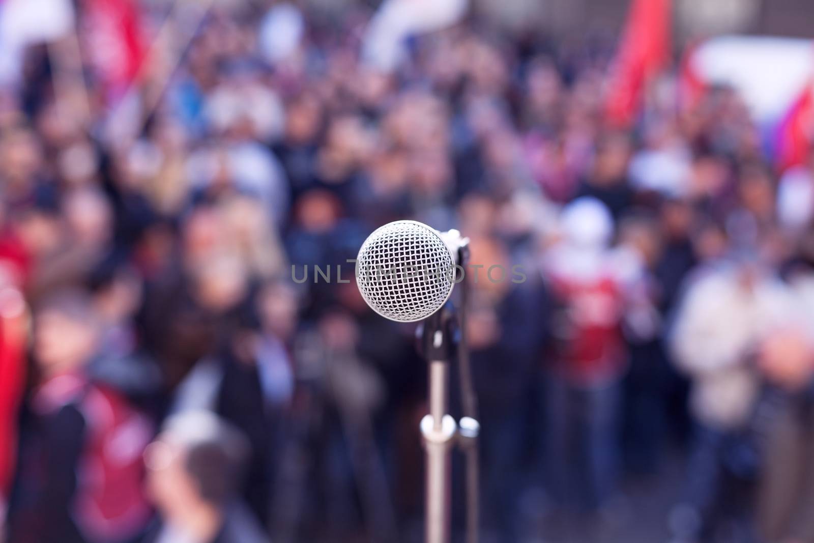 Street protest. Political rally. Microphone in focus against blurred crowd. 