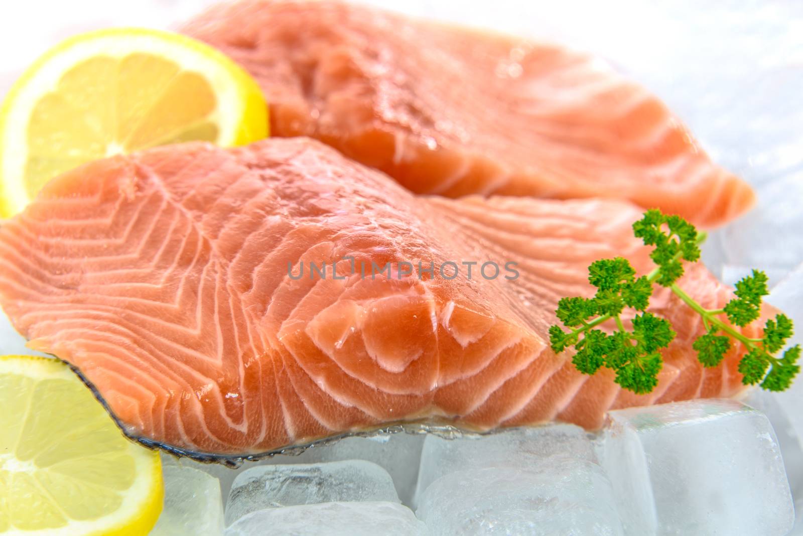Fresh Salmon fillet with parsley and lemon in ice.