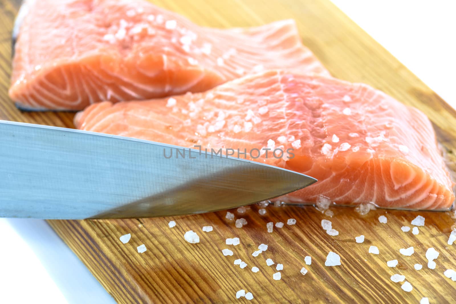 Patches of fresh salmon marinated with sea salt and cutting on a wooden board