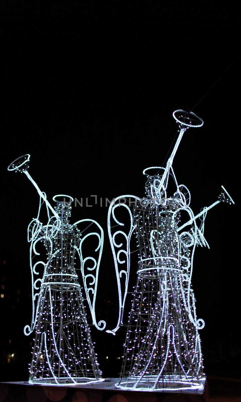 luminous figures of three angels with trumpets at night