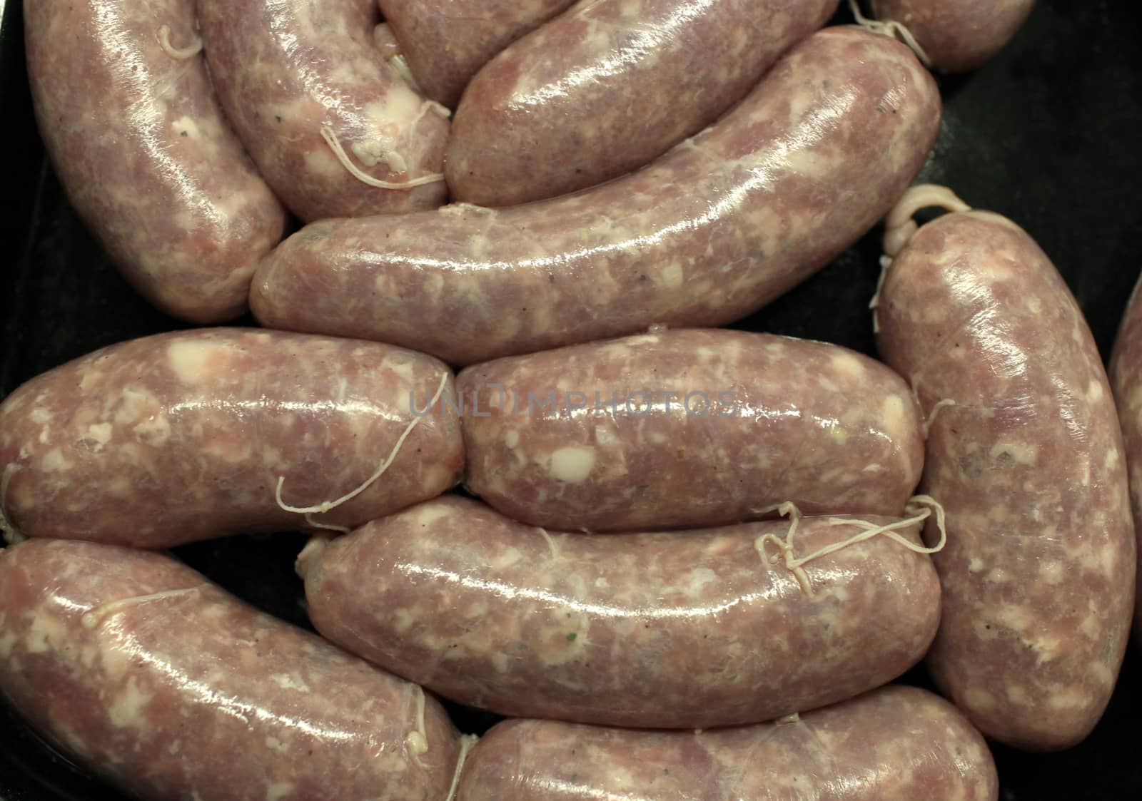 raw meat sausages on black background  above close-up