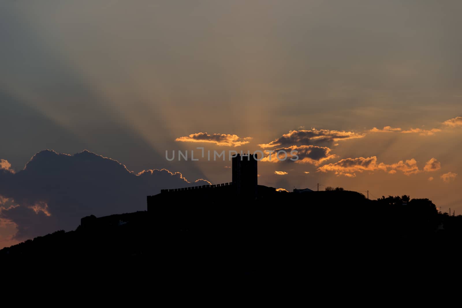 sunrays from the clouds over the catle of portel in portugal