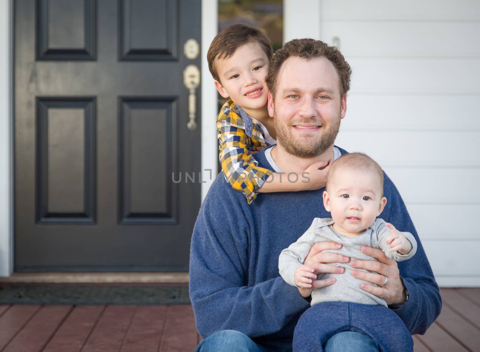 Young Mixed Race Father and Sons on Front Porch.