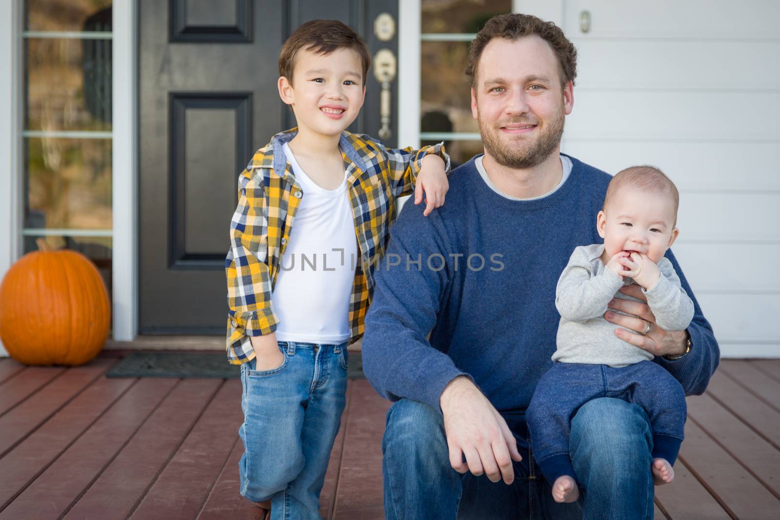Young Mixed Race Father and Sons on Front Porch.