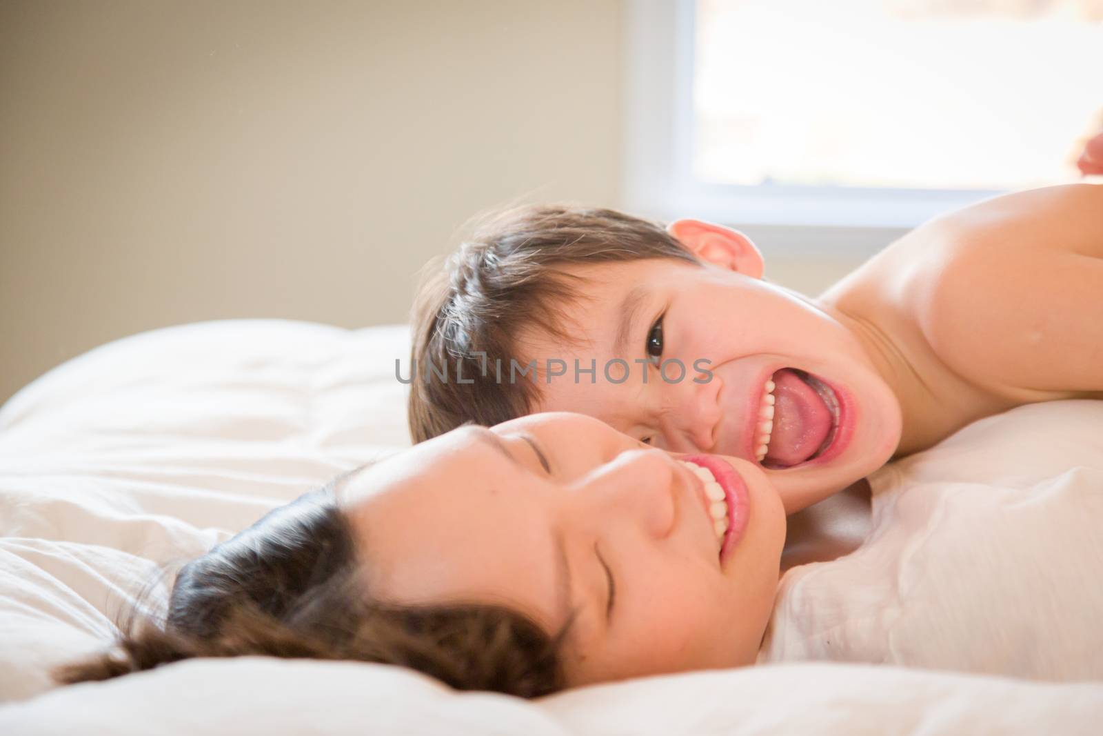 Young Mixed Race Chinese and Caucasian Boy Laying In His Bed with His Mother.