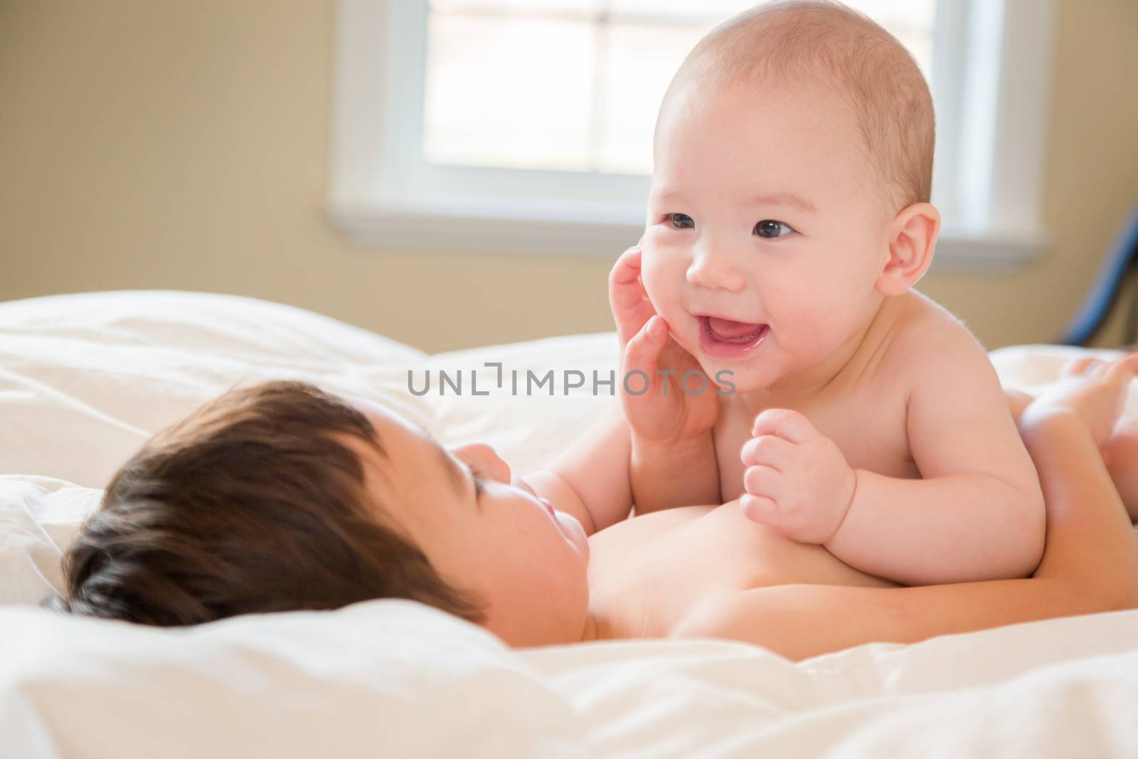 Young Mixed Race Chinese and Caucasian Baby Brothers Having Fun on Their Blanket.