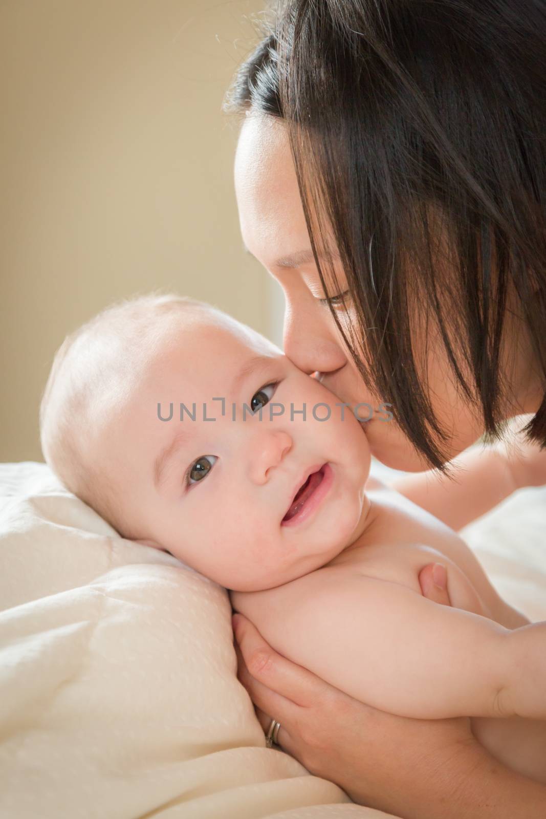 Young Mixed Race Chinese and Caucasian Baby Boy Laying In His Bed with His Mother.