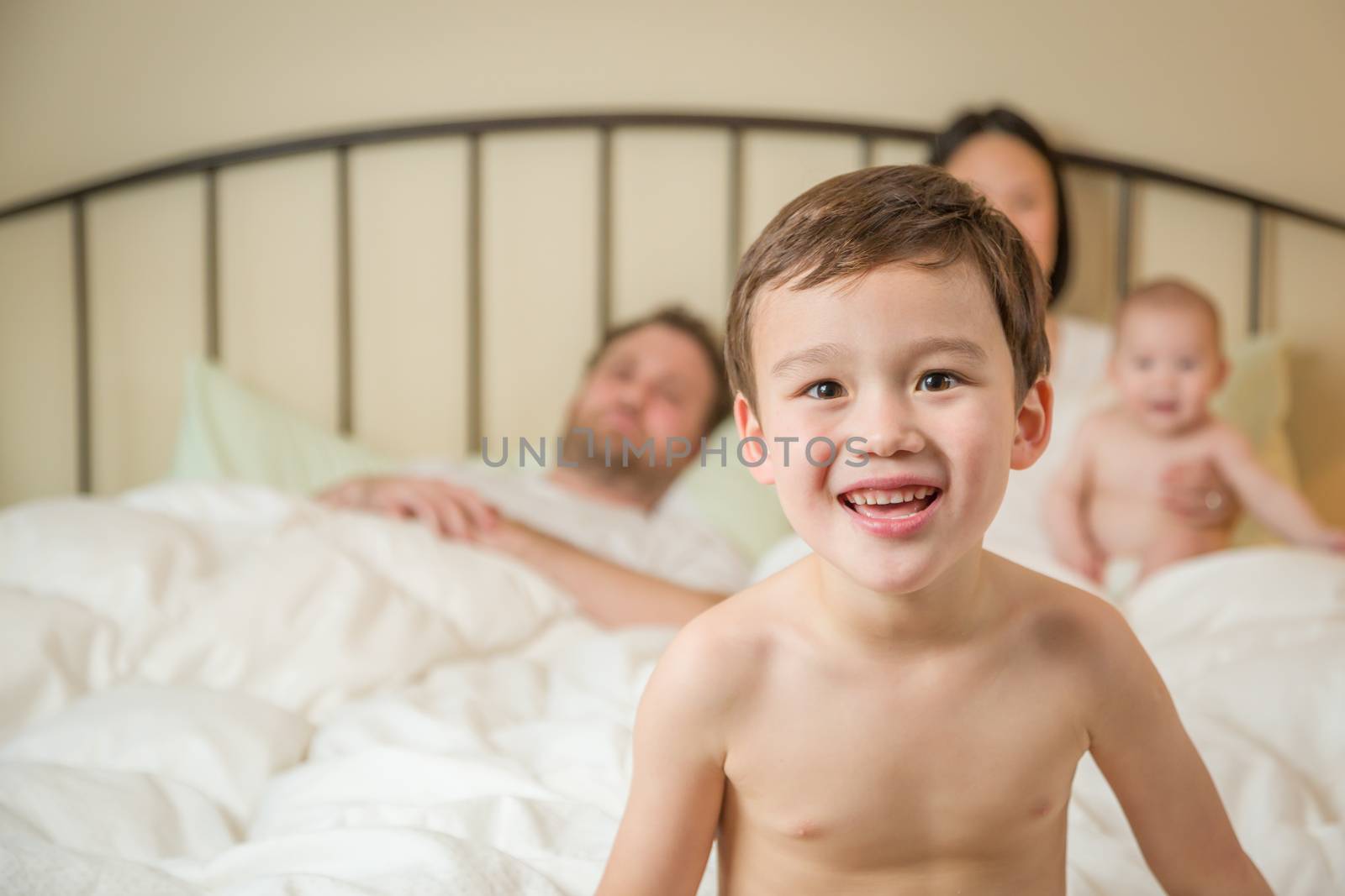 Mixed Race Chinese and Caucasian Boy Laying In Bed with His Fami by Feverpitched