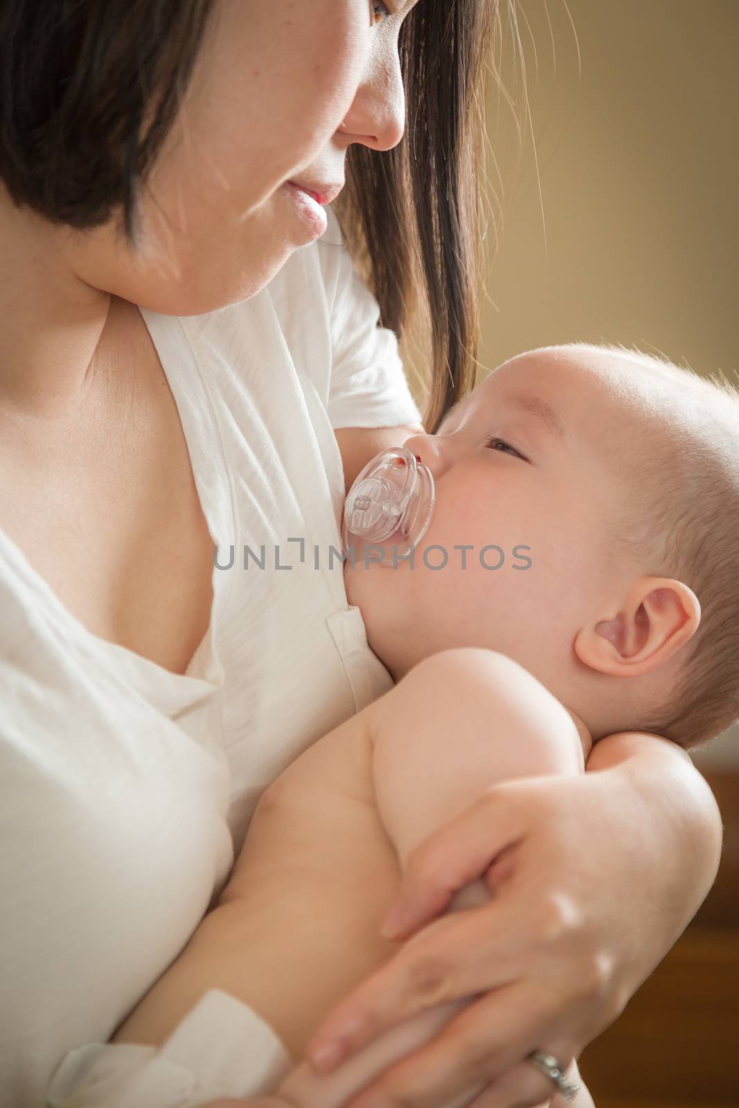 Mixed Race Chinese and Caucasian Baby Boy Being Held By His Mother.