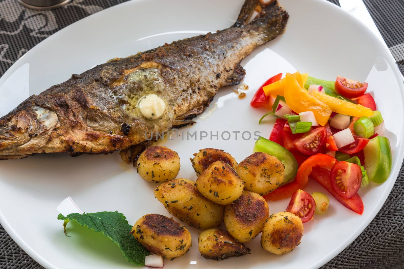 Roasted trout on white plate by JFsPic