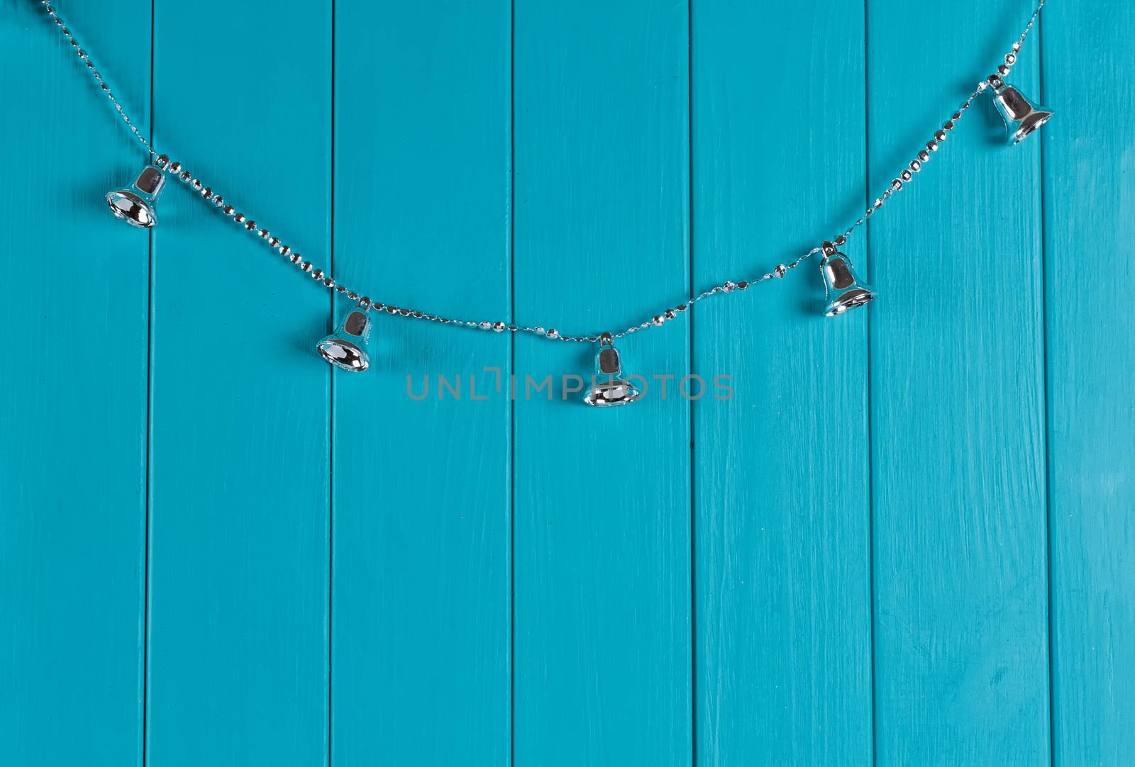 Christmas silver bell on blue wall. Copy space in right side