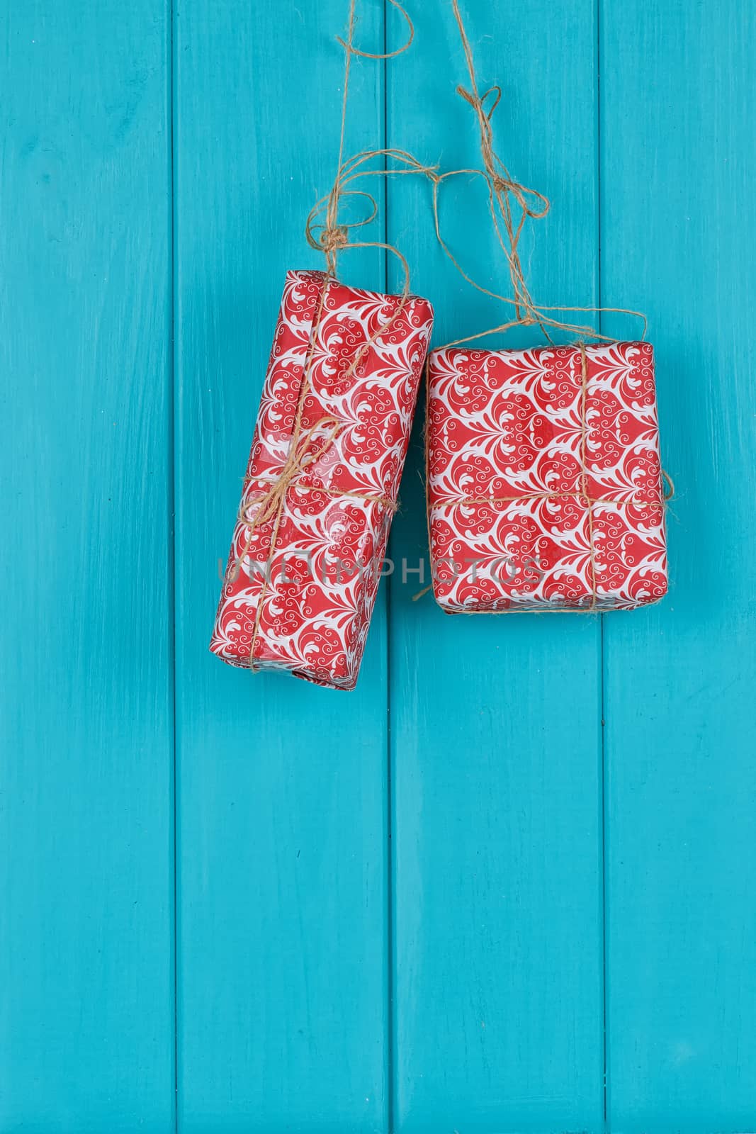 Christmas decorations hanging on rope in front of blue wooden background. by victosha