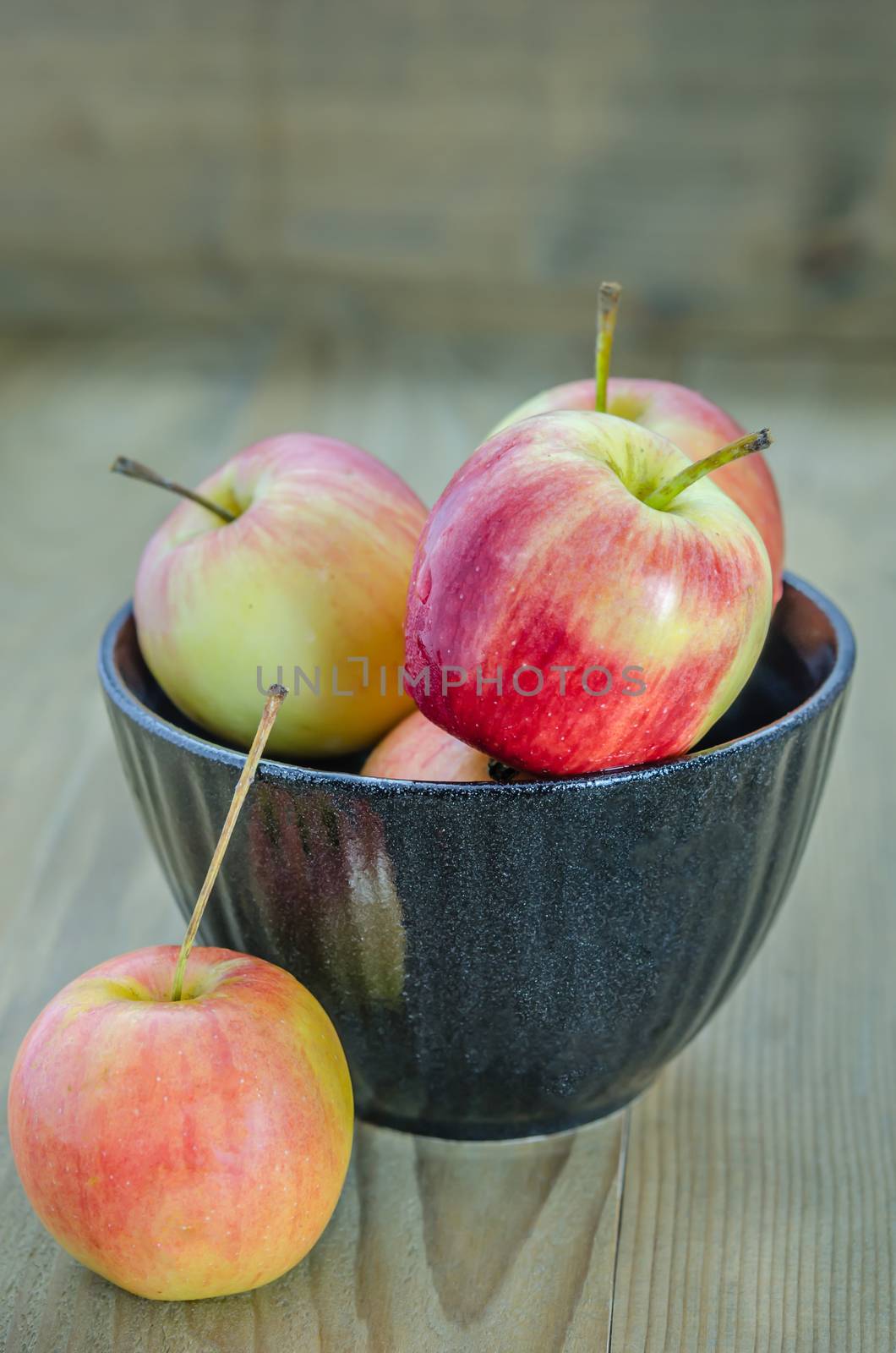 Red and yellow apple with black bowl