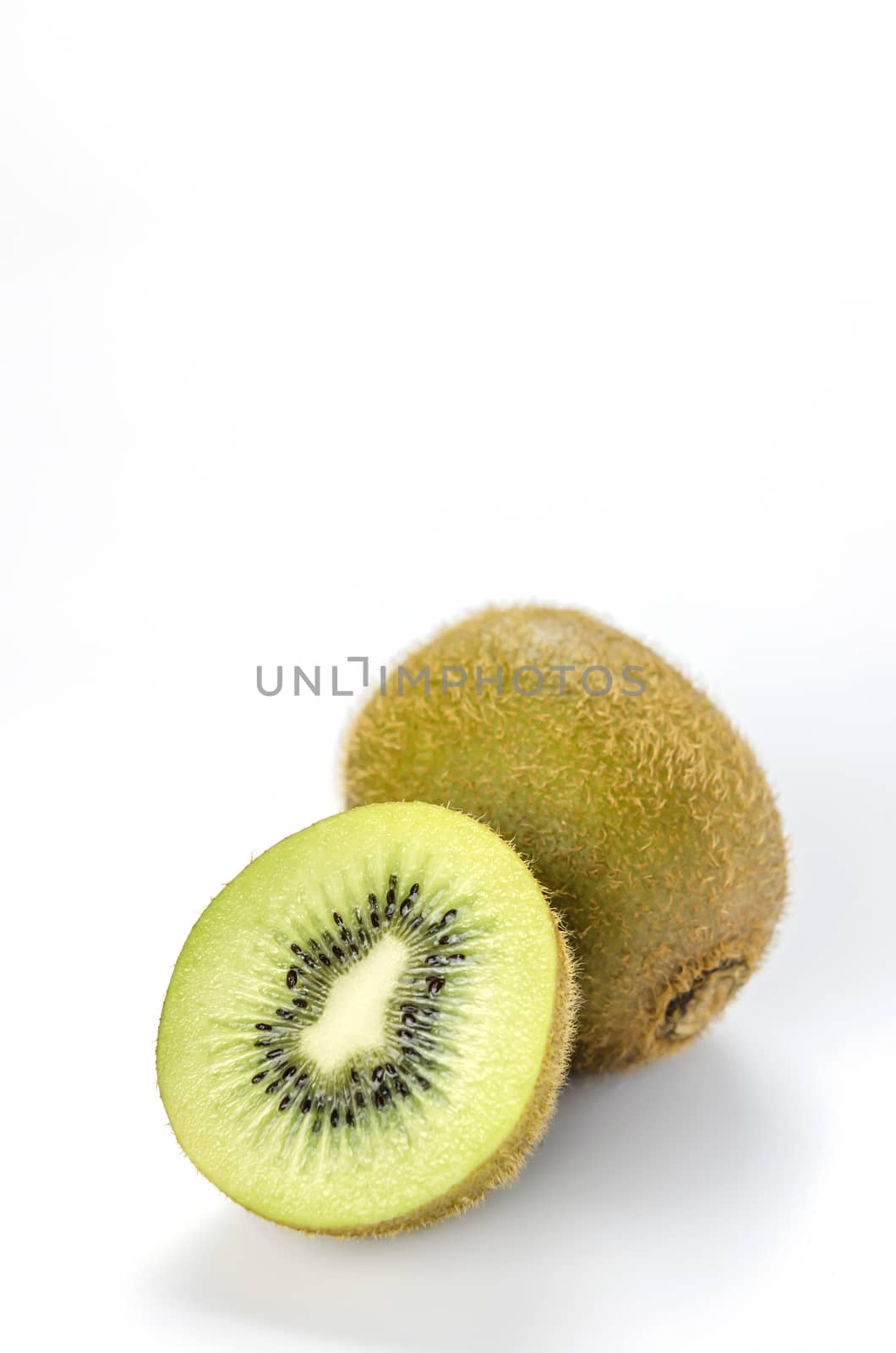 delicious whole kiwi fruit and half on white background