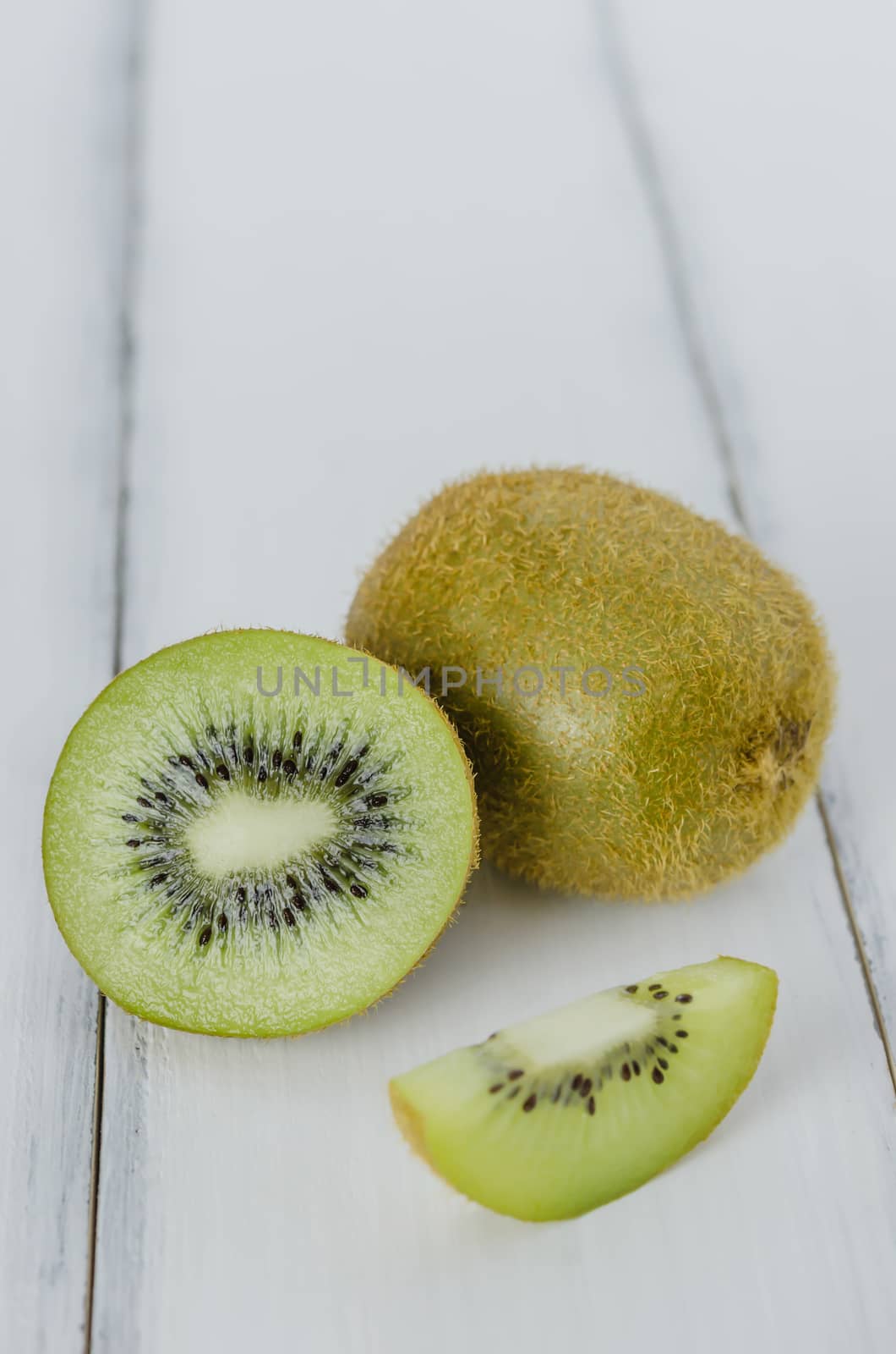 delicious whole kiwi fruit and sliced on wooden background