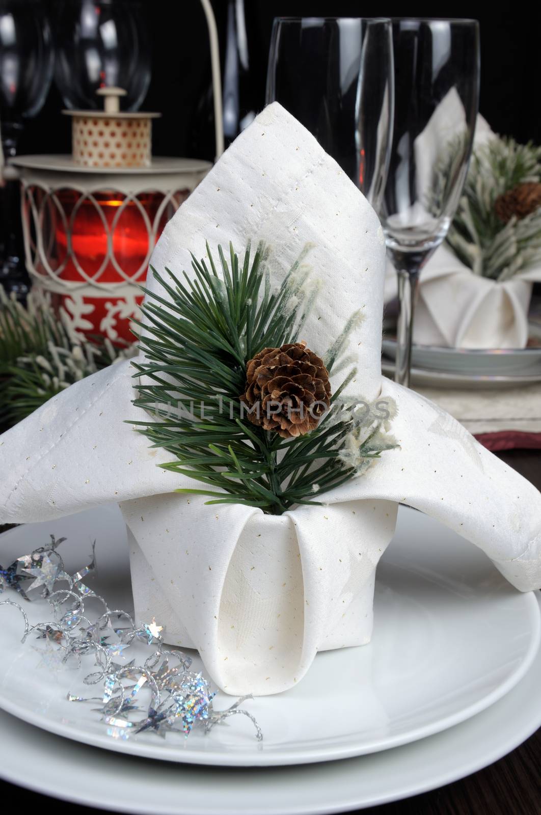 A fragment of a Christmas table setting napkin decorated with pine branches pinecone
