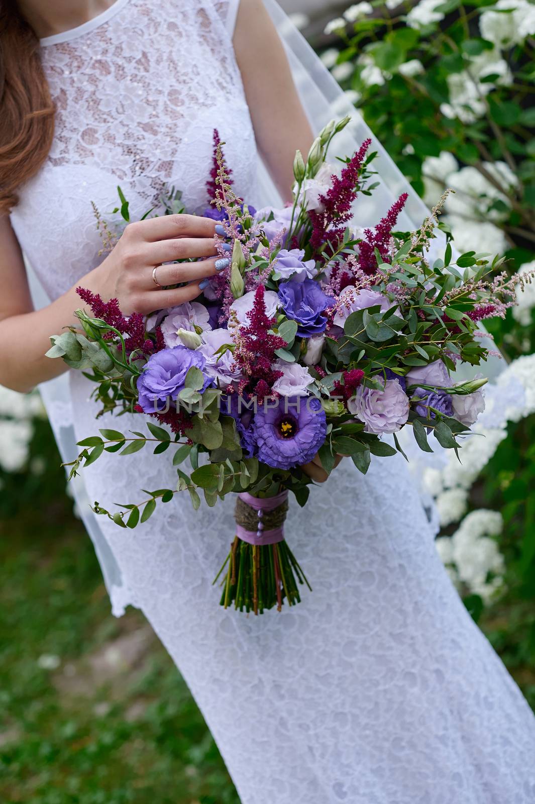 bride holding a wedding bouquet on walk.