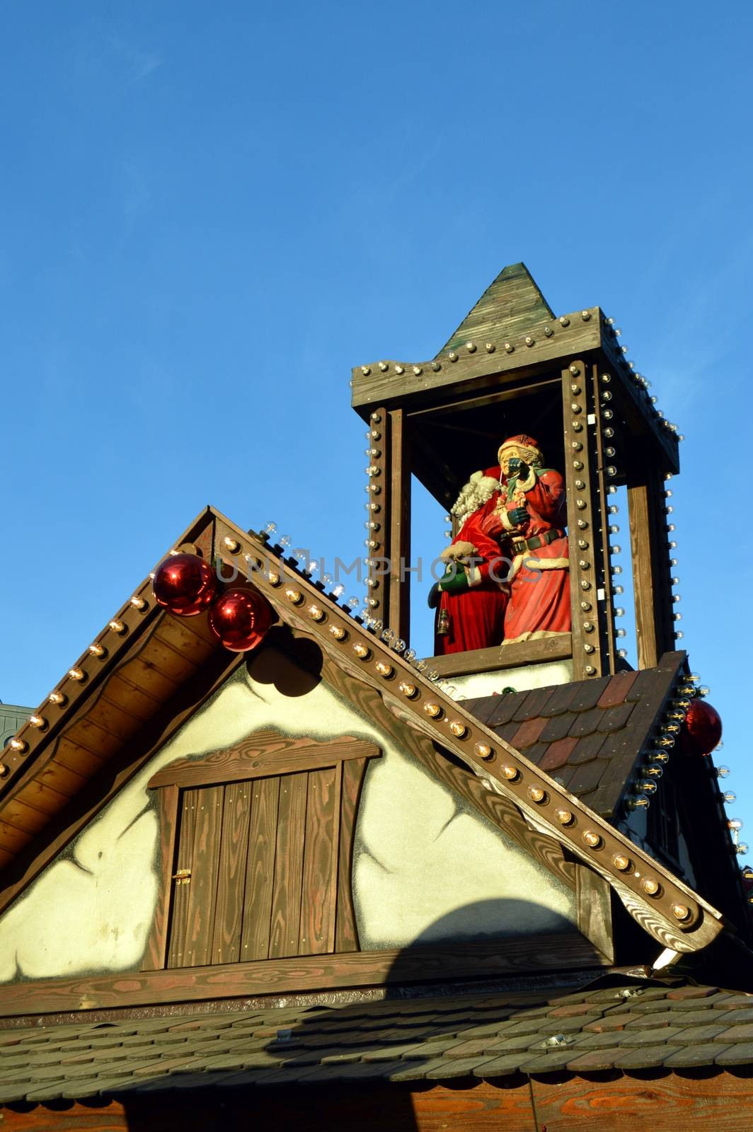 Mom and papa christmas on a wooden tower on a cottage