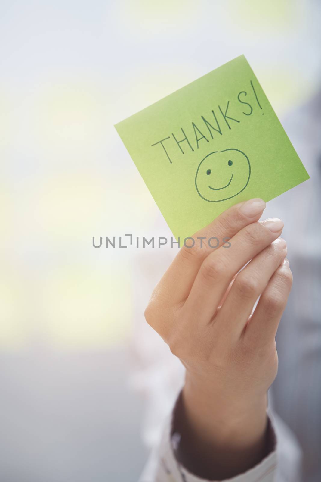 Woman holding sticky note with Thanks text