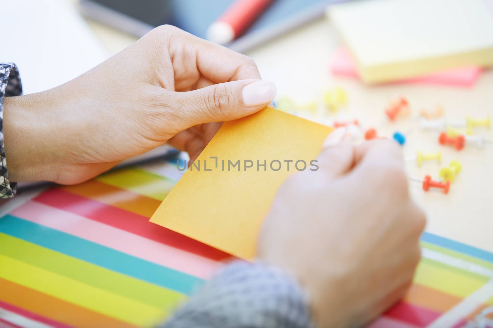 Woman at office holding adhesive note by Novic