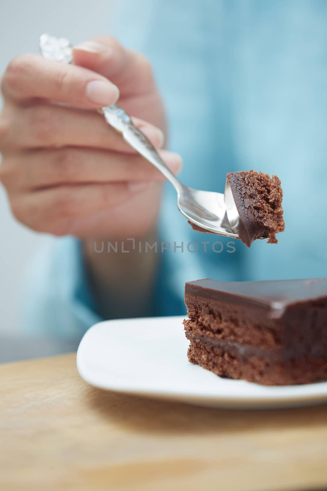 Hand of woman eating chocolate cake