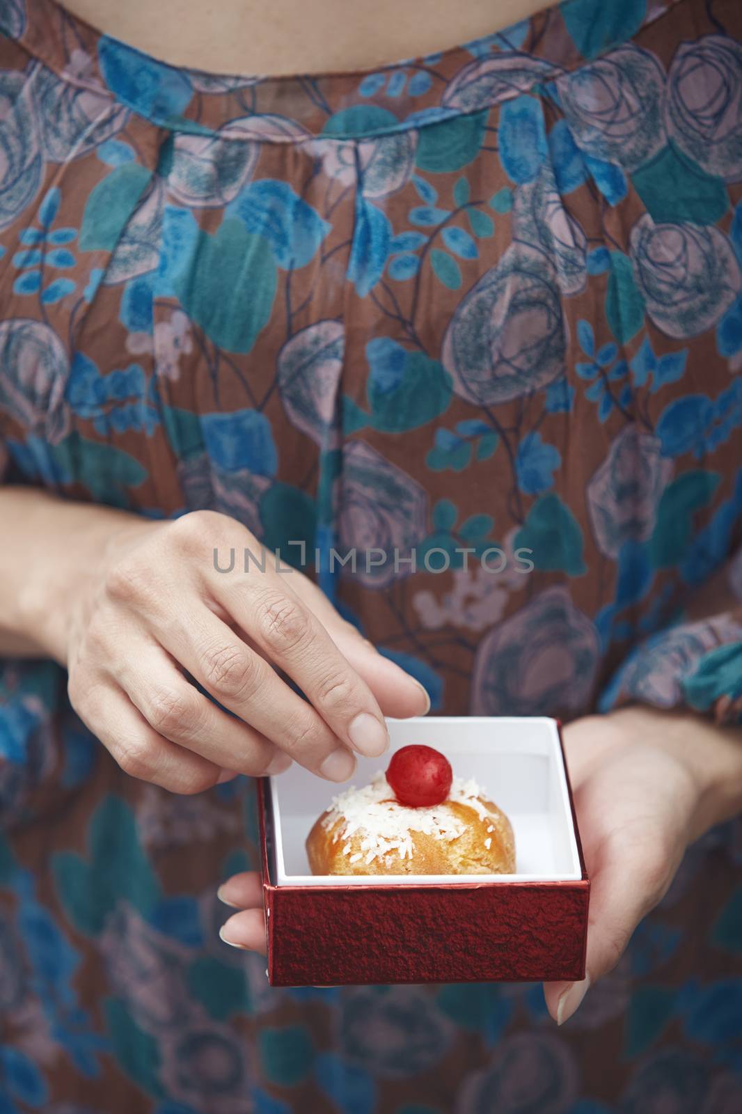 Woman holding Christmas eclair at home