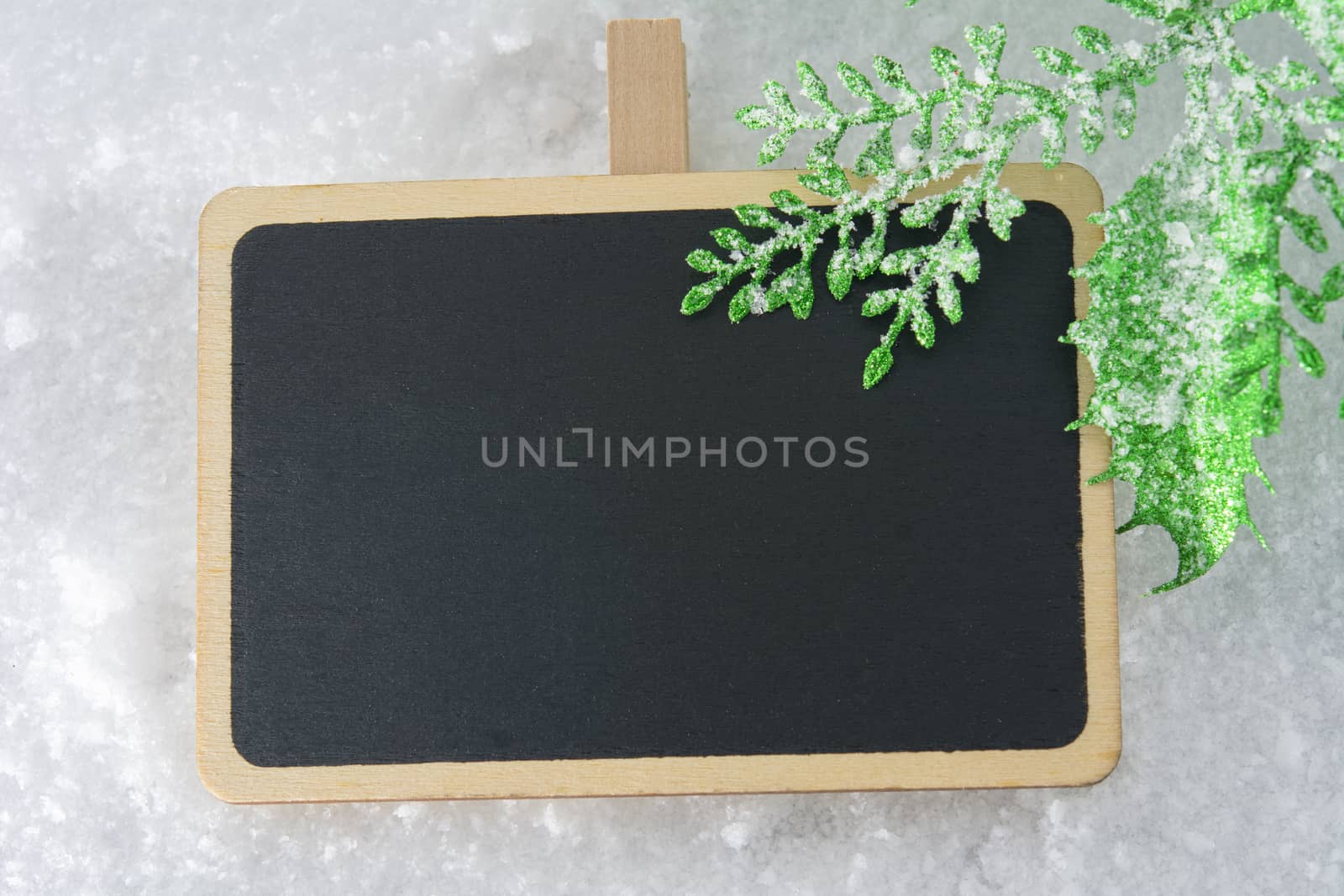 Blank blackboard on snow with Christmas decoration