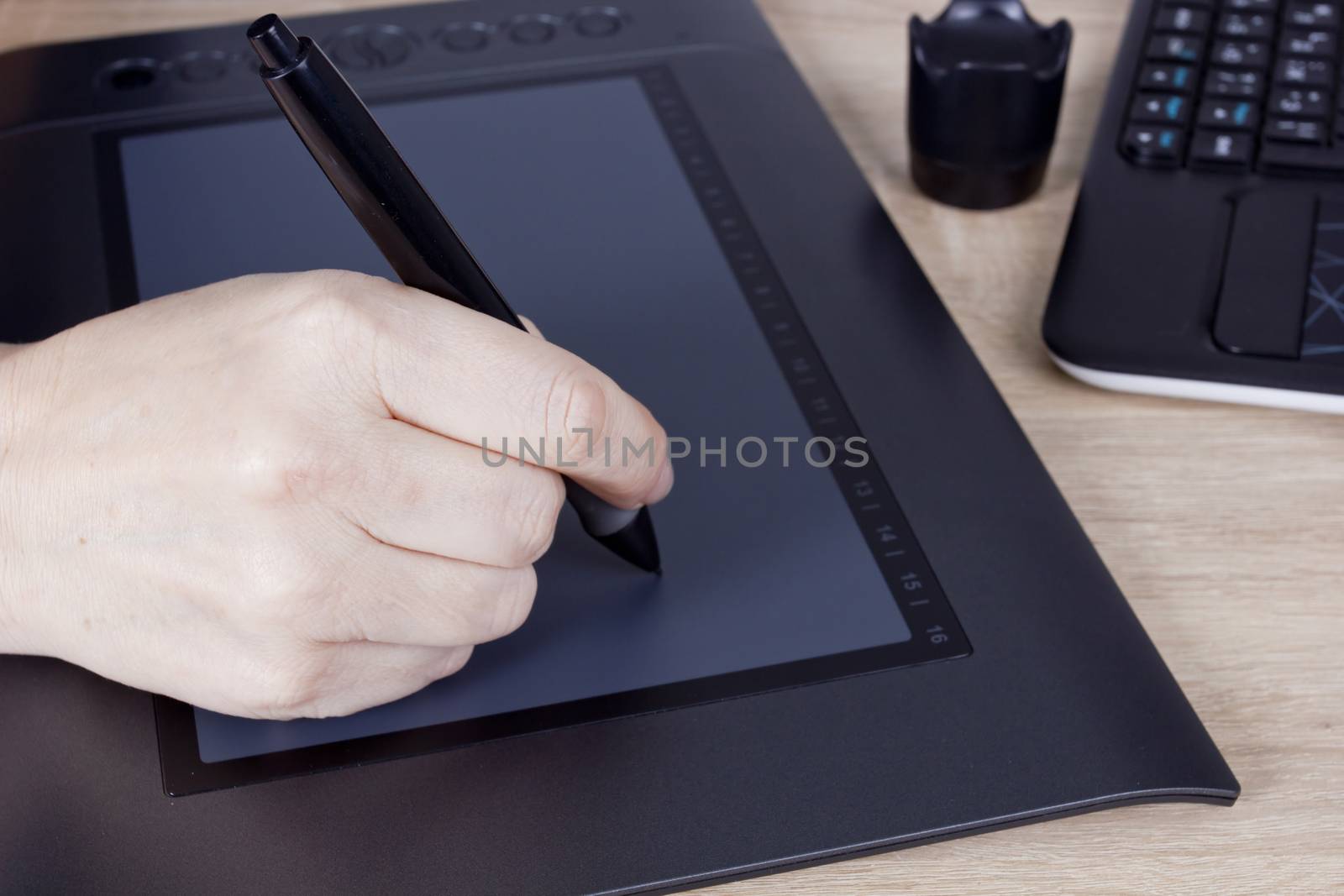 Hand graphic designer with a digital pen and tablet